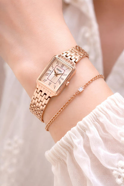 Rose gold watch on a wrist with a blurred background
